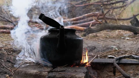 Blackened with Soot Kettle is Boiling over an Open Fire on a Tourist Bonfire Stock Footage 135427883