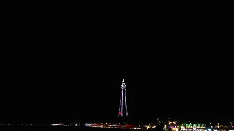 Blackpool tower illuminates multiple colours in the dark night sky for the Stock Footage 139309991