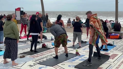 Blackpool, UK 2025 Aug 10; Yoga class performing on Tower Headland. 4k video Stock Footage 314708208