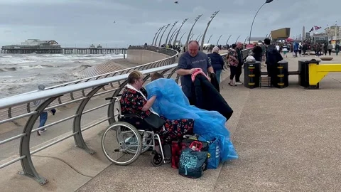 Blackpool, UK 2025 Aug 10. Airshow arrivals with windy day rain jacket. 4k video Stock Footage 314777088