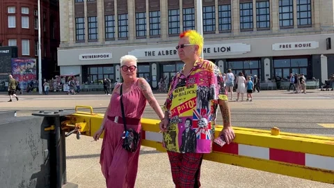 Blackpool, UK. 2025 Aug, 11: Colourful Punks on the seafront promenade. 4k video Stock Footage 314642085