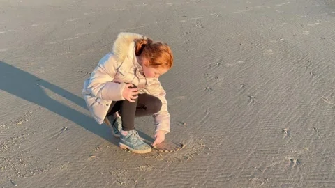 Blackpool, UK. 2025 Dec, 25; Child drawing heart shape on sandy beach Video stock 300613495