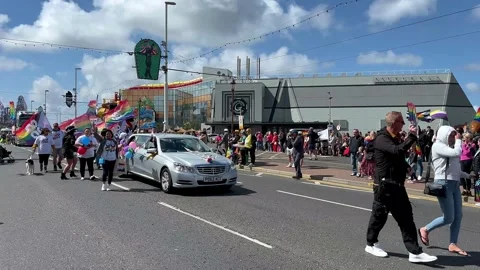 Blackpool, UK 8 June 2024: Disabled pair with pet Summer rainbow Pride festival Stock Footage 277105205