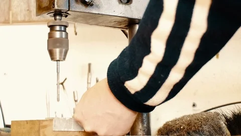 A blacksmith is about to make a hole on an iron plate with a drill press Stock Footage 87712621