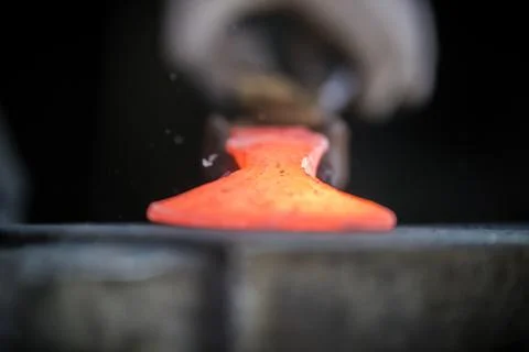 Blacksmith and anvil. Blacksmith working with red hot metal workpiece of new Stock Photos
