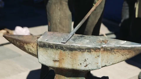 The blacksmith and assistant manually forging the molten metal on the anvil i Stockbeeldmateriaal 110836743