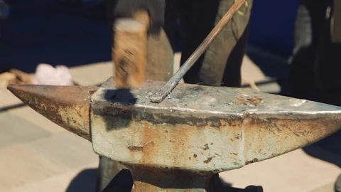 The blacksmith and assistant manually forging the molten metal on the anvil i Stock-Footage 111265325