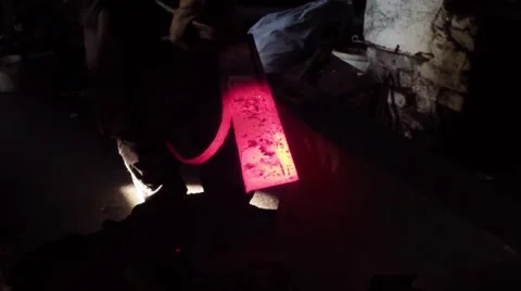 Blacksmith and His Apprentice Together Give Form Workpiece Into a Water-Powered Video stock 59760978