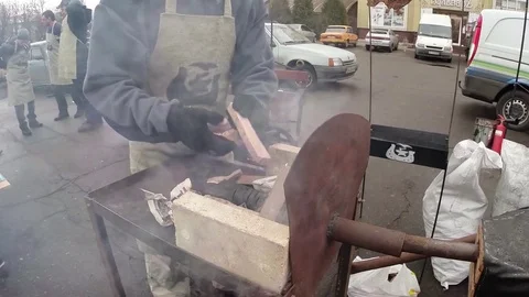 Blacksmith in Apron Ignites Fire in The Open Domain Using Wood Stock Footage 74794411