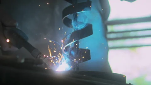 Blacksmith arc welding a piece of spiraled metal Stock Footage 275505332