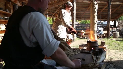 Blacksmith with assistant work in the forge Stock Footage 54688534