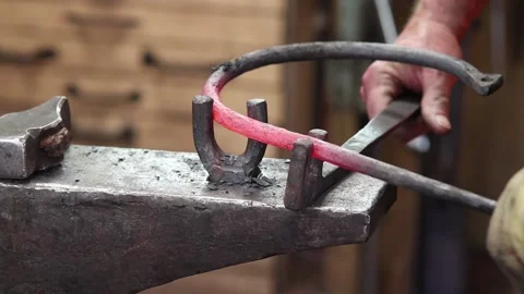 Blacksmith bending a round ring at the anvil Stock Footage 133954190