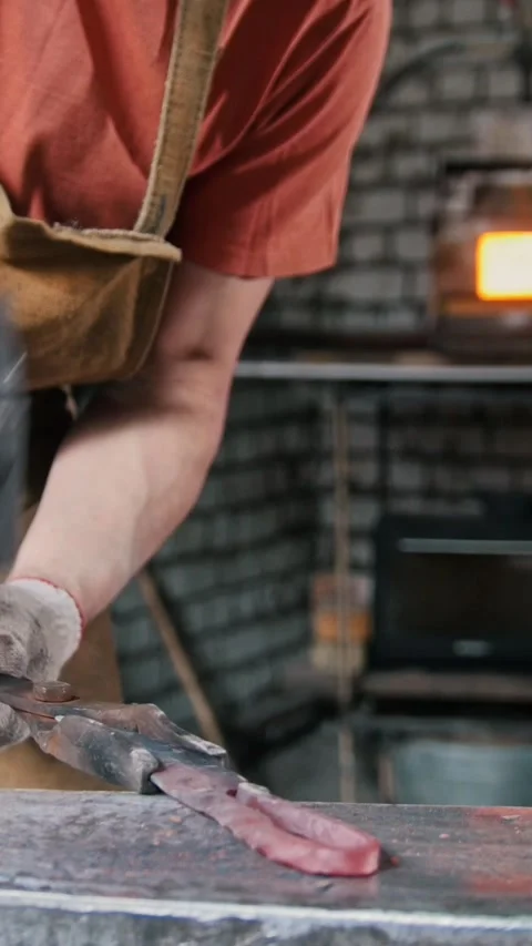 The blacksmith bends iron rod on the anvil with hammer, metal work Stock Footage 332614507