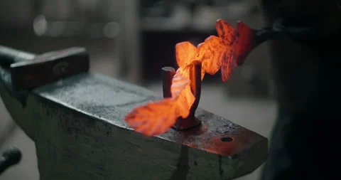 Blacksmith bends the red hot decorative metal product on the anvil, decorative Stock Footage 151769677