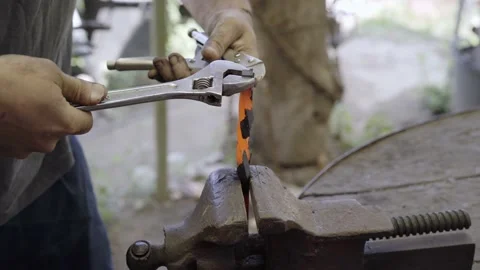 Blacksmith braiding metal in the old forge. Small craftsman working in a Stock Footage 172048186