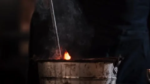 Blacksmith cooling metal in water Stock Footage 304978046
