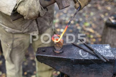 Blacksmith cut out a buckle with hammer and chisel Stock Photos