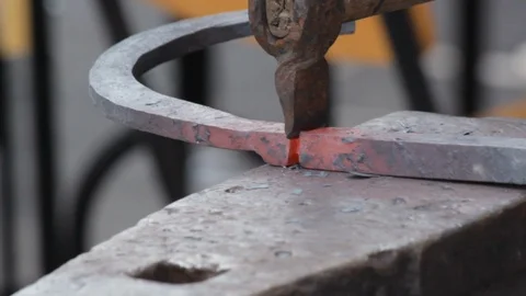 A blacksmith cuts off by chisel and hammer a piece of hot iron bar. Stock Footage 120260381