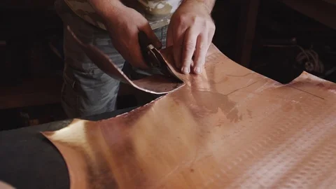 The blacksmith cuts a round workpiece off a sheet of copper. Stock Footage 94937318
