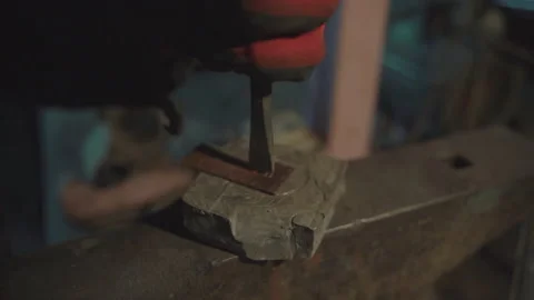 Blacksmith cutting out hole into copper plate in smithy workshop. Damascus st Stock Footage 194525018