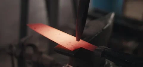 Blacksmith engraving a knife with a hammer and a chisel Stock Footage 131780060