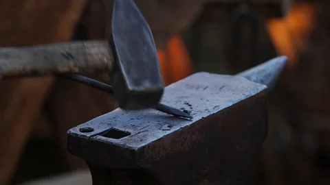 Blacksmith father and son forge hot steel on an anvil by hammer. Making Stock Footage 114928785