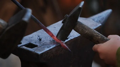 Blacksmith father and son forge hot steel on an anvil by hammer. Making Stock-Footage 114928883
