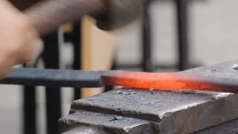 A blacksmith forge by hammer hot iron bar to make a horseshoe. Stock Footage 120260349