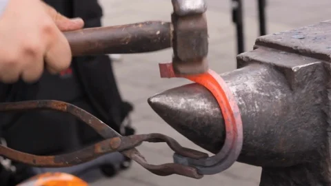 A blacksmith forge by hammer hot iron bar to make a horseshoe. Stock Footage 120260510
