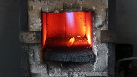 Blacksmith forge oven with hot flame. Smith heating iron piece of steel in fire Stock Footage 168970852
