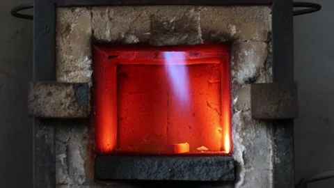 Blacksmith forge oven with hot flame. Smith heating iron piece of steel in fire Stock Footage 188680157