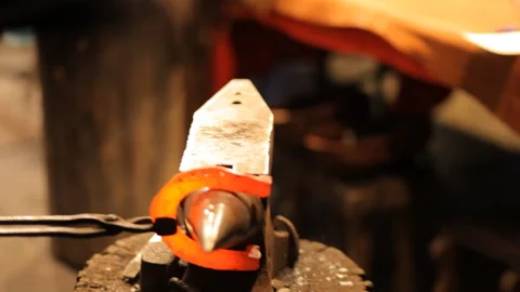 Blacksmith forges a horseshoe in a craft workshop. Horseshoe for good luck Stock Footage 98158624