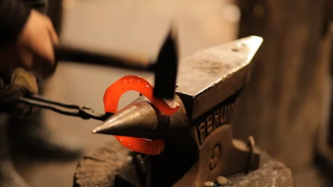 Blacksmith forges a horseshoe in a craft workshop. Horseshoe for good luck Stock Footage 98158765