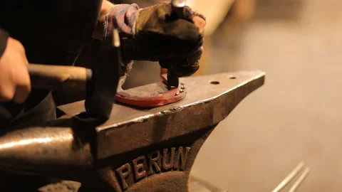 Blacksmith forges a horseshoe in a craft workshop. Horseshoe for good luck Stock Footage 98158847