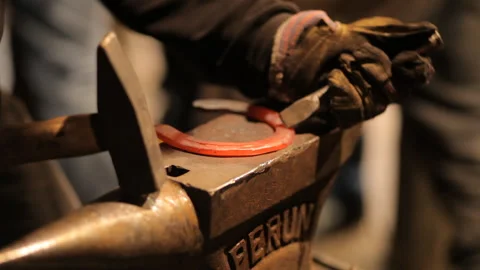 Blacksmith forges a horseshoe in a craft workshop. Horseshoe for good luck Stock Footage 98159110