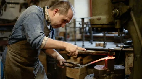 Blacksmith forges iron on the anvil Stock Footage 67674354