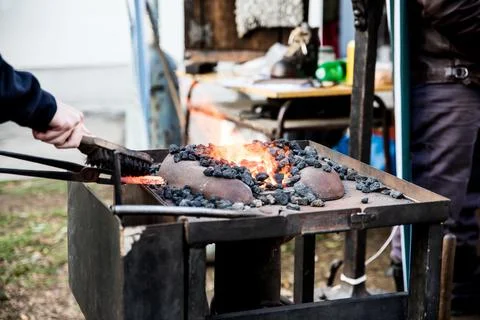 The blacksmith forges iron. Blacksmithing concept. Stock Photos