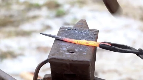 Blacksmith forges iron in the street. Knife, hammer, anvil. Stock Footage 74007963