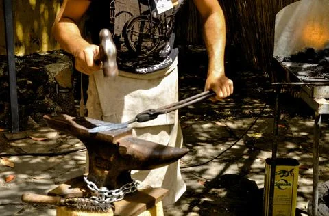 The blacksmith forges the knives with blows Stock Photos