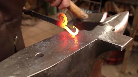 Blacksmith forging a decorative scroll on a hinge Stock Footage 153474658