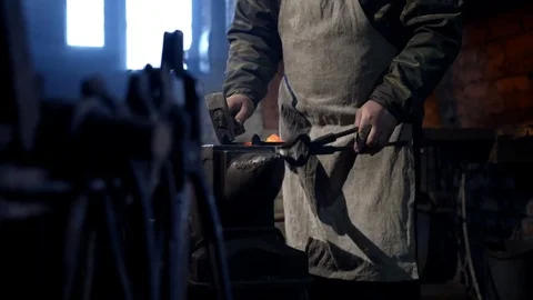 Blacksmith forging a horseshoe on an anvil. A hammer striking red-hot iron Stock Footage 72347791