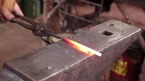 Blacksmith forging hot iron on the anvil Stock Footage 133001319