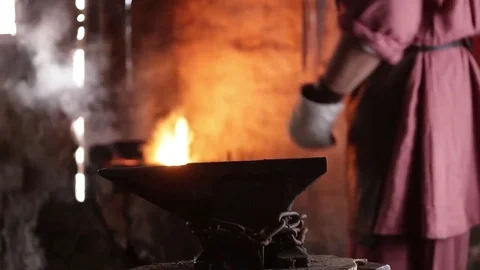 Blacksmith forging the molten metal on the anvil in smithy Vidéo 70825847