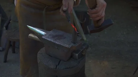 Blacksmith forging the molten metal on the anvil in smithy Stock Footage 108826537