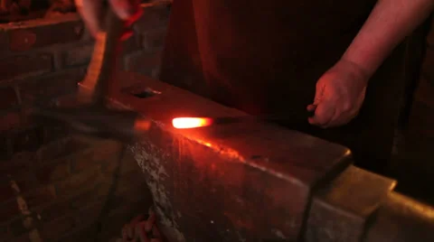 Blacksmith forging red hot iron rod on anvil, puts back in fire, closeup Stock Footage 39016728