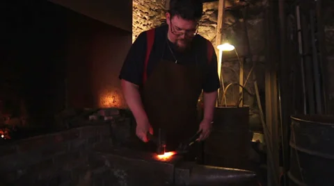 Blacksmith forging red hot iron, sparks fly, slow motion, medium shot Stock Footage 39021273