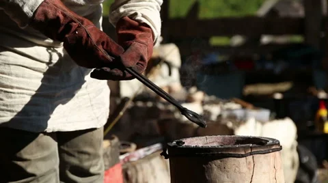 Blacksmith forging tongs corrects the crucible in the furnace Stock Footage 54688328