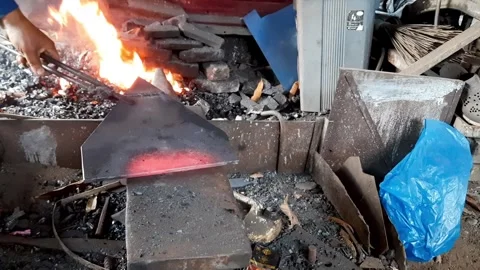 Blacksmith Forging Triangular Steel on Anvil Near Furnace Stock Footage 310077805