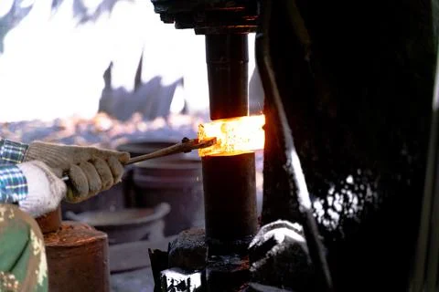 The blacksmith is forging very hot iron to make various tools. Stock Photos