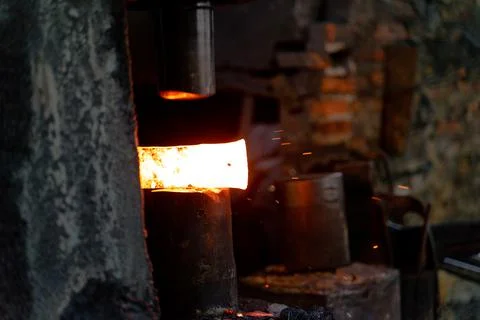 The blacksmith is forging very hot iron to make various tools. Stock Photos